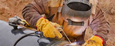 Professioneller Schweißer bei Schweißarbeiten an Öl und Gas Rohrleitungen